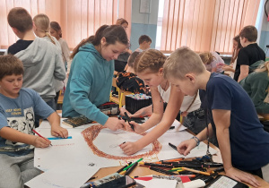 Uczniowie wykonują prace plastyczną.