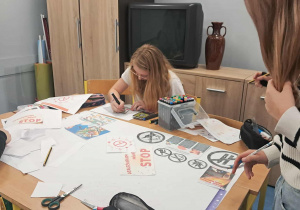 Uczniowie tworzą plakaty edukacyjne.