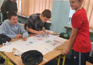Uczniowie tworzą plakaty edukacyjne.