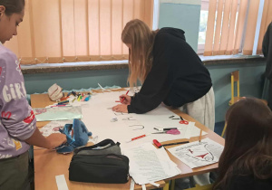 Uczniowie tworzą plakaty edukacyjne.