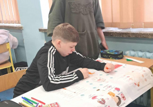 Uczniowie tworzą plakaty edukacyjne.