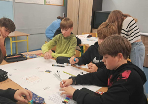 Uczniowie tworzą plakaty edukacyjne.