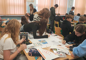 Uczniowie tworzą plakaty edukacyjne.