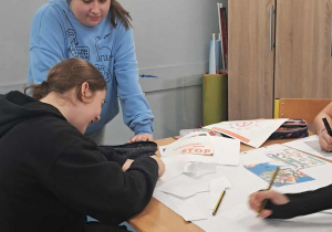 Uczniowie tworzą plakaty edukacyjne.