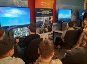 Uczniowie w symulatorze lotu.