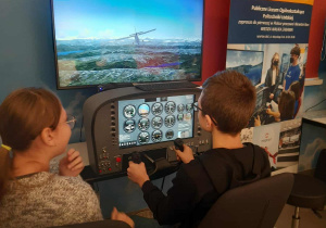 Uczniowie w symulatorze lotu.