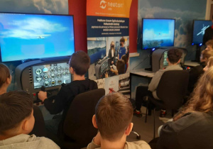 Uczniowie w symulatorze lotu.